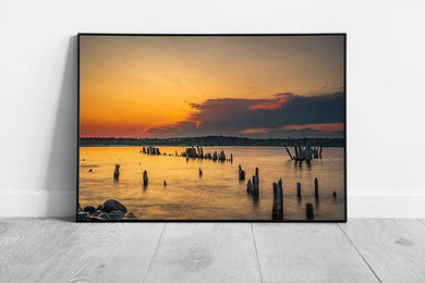 Vibrant Seaside Sunset: Framed Coastal Artwork with Weathered Wooden Ruins Above Serene Seashore - Print Store
